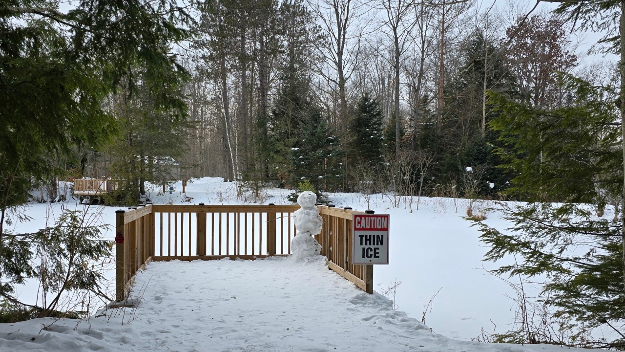 A Caution Thin Ice sign at the levee on Papa Bear Pond at the Tiffin