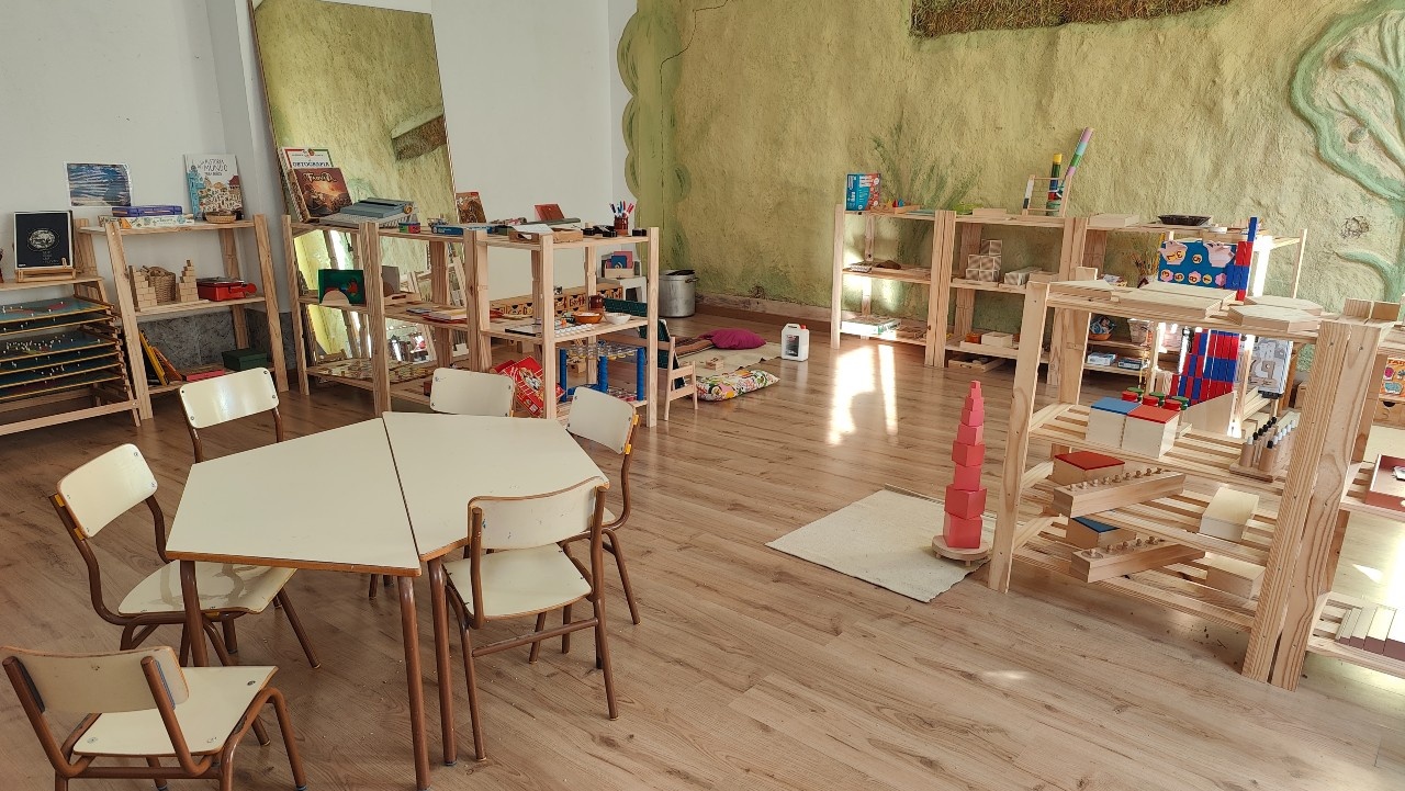 Foto del espacio Maitessori con mesas, sillas, y estanterías con juegos y demás elementos para el acompañamiento de txikis