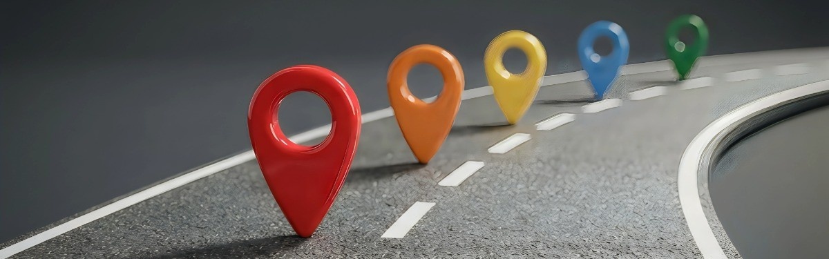 Curved road with five colourful map pin markers — red, orange, yellow, blue, and green — symbolising milestones or progress along a journey