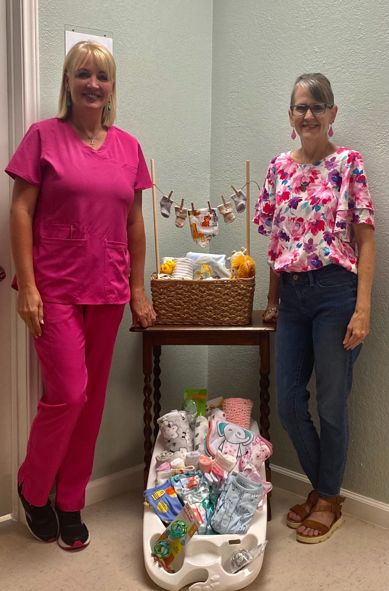 Mrs. Anne pictured with Renee Arriaga next to a display of baby toys and clothes.