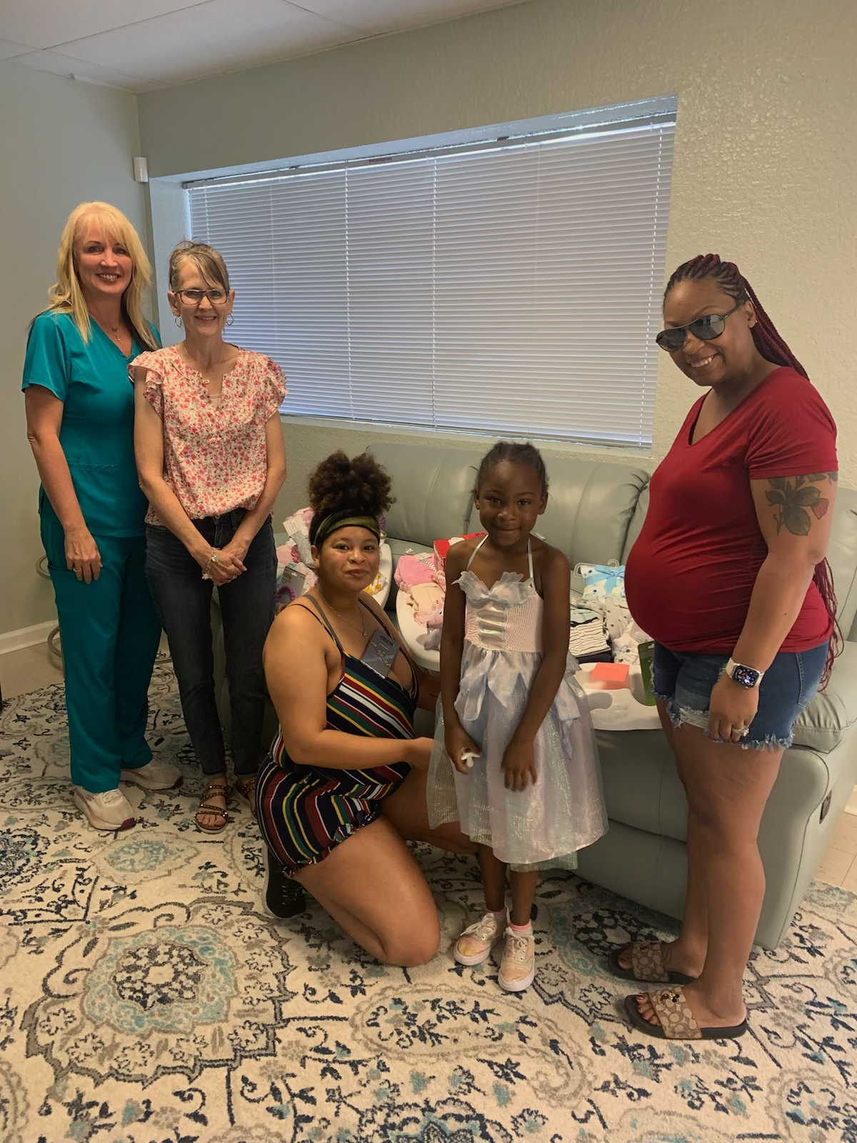 Mrs. Anne pictured with a family, giving them baby equipment with Renee Arriaga