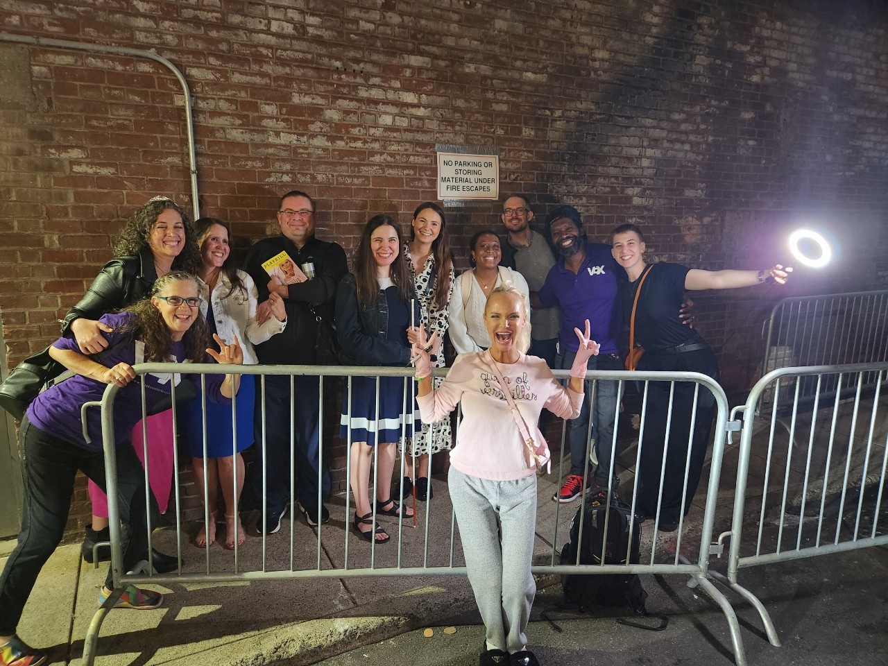 Group photo of Deaf, DeafBlind, hearing Vox members, and interpreter ushers in the alley near the stage door with Kristin Chenoweth, all smiling. For the full image description, click on the embedded Facebook link.
