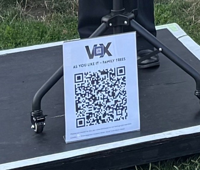 QR code of show materials printed on paper and in a plastic stand up.