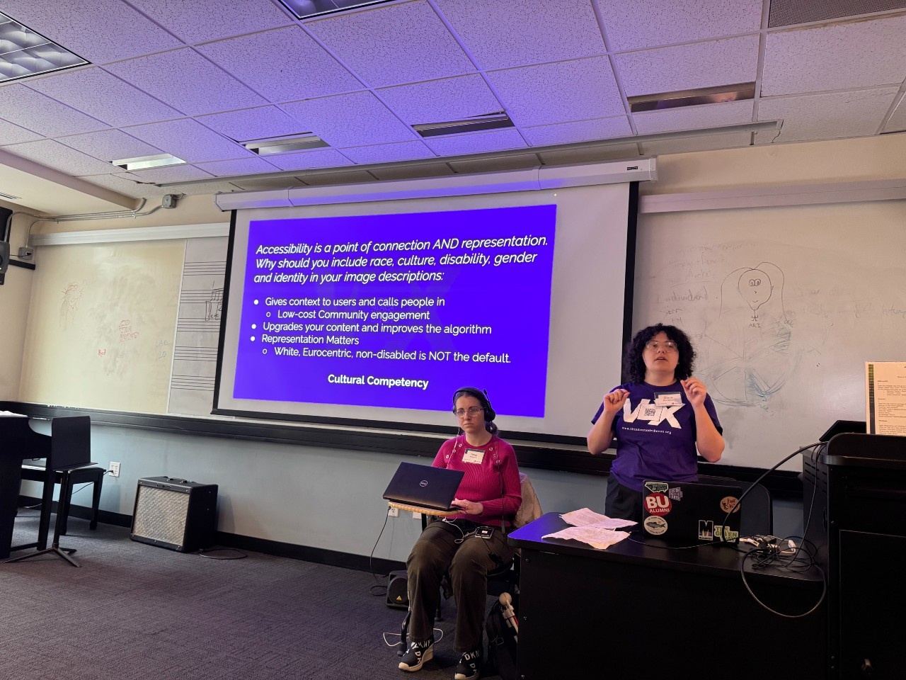 Tanja Milojevic and Olivia Reinebach present in a classroom at Berklee with a presentation slide behind them.