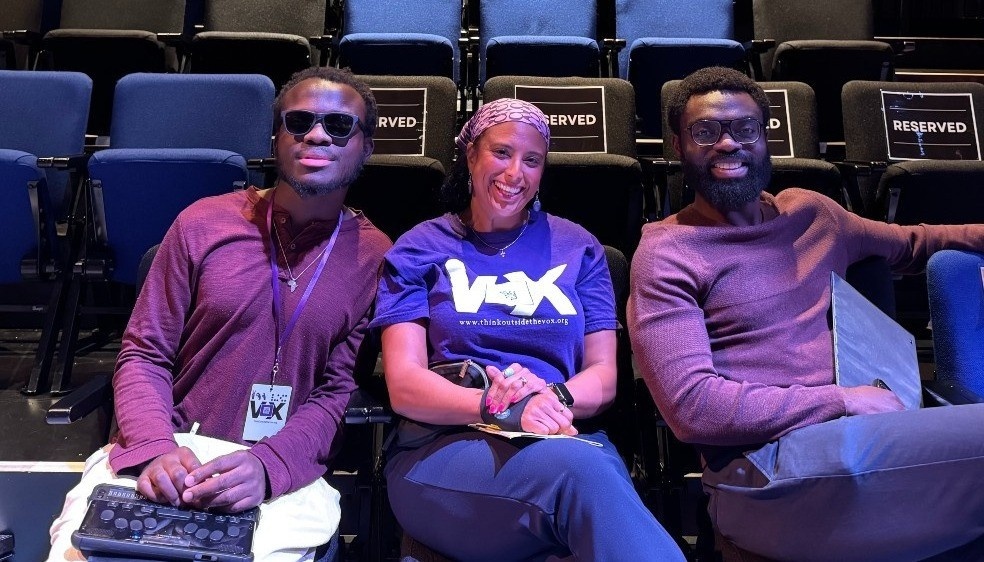 The Ceremony AD team Kwaku Maria and Joshua sitting in the seats, smiling.