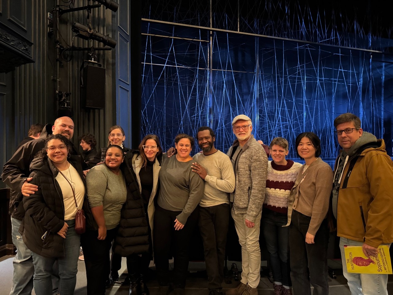 A large group photo of 11 Deaf, hearing, BIPOC and white folks of varying ages, including the Sojourners ASL team, Vox DASL cohort members and Deaf community members who attended the show.