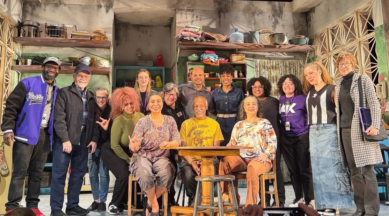 Voxers Christopher and Aimee Robinson, Ingrid O'Dell, Kristin Johnson, Mangos ASL team Ivy Velez, Juana Aguilar, Joe Toledo, Olivia Reinebach, Jessenia Kolaco, Mangos cast and Deaf community stand and sit on stage, smiling.