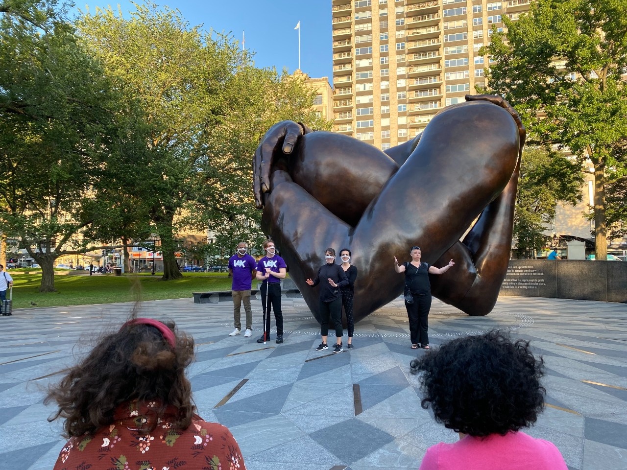 Kerry Thompson, a DeafBlind woman, teaches a salsa lesson at the Embrace Memorial statue in Boston Common on a summer evening