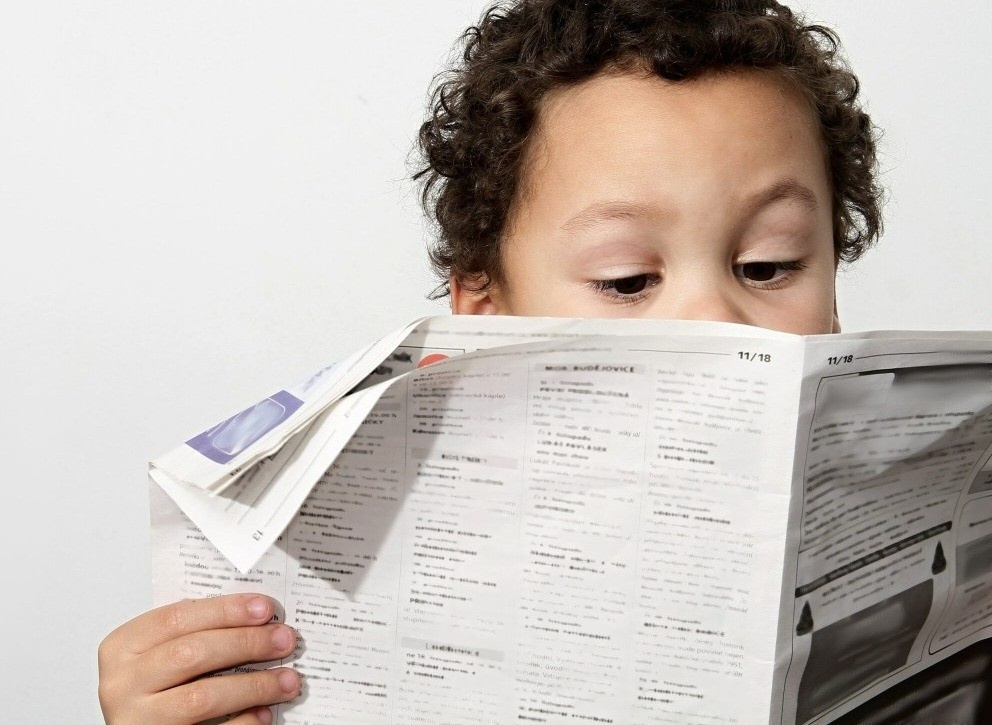Boy reading newspaper