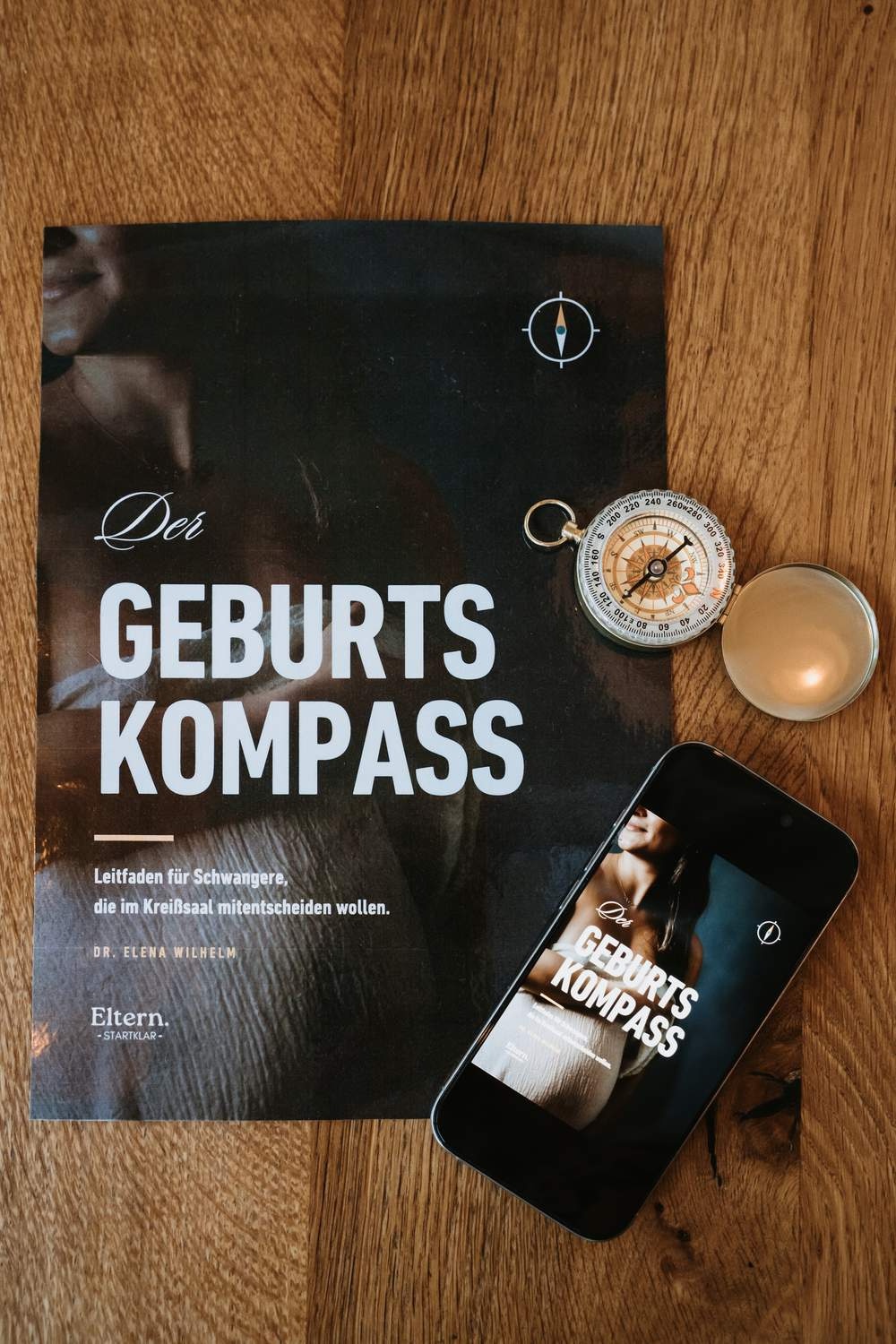 Der Geburtskompass gedruckt und auf dem Handy, daneben ein Taschenkompass