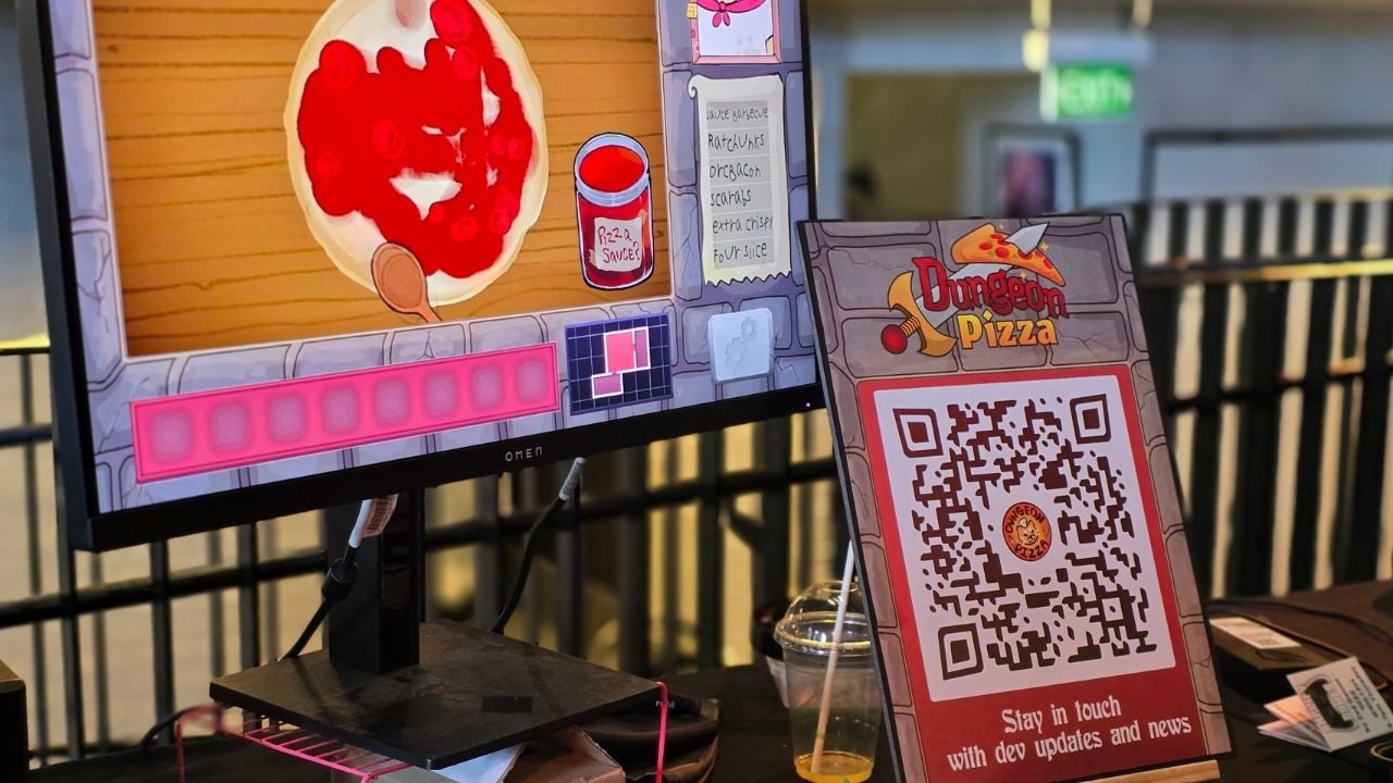 Image description: High quality image of the Dungeon Pizza booth, with the newsletter sign up poster in the foreground.