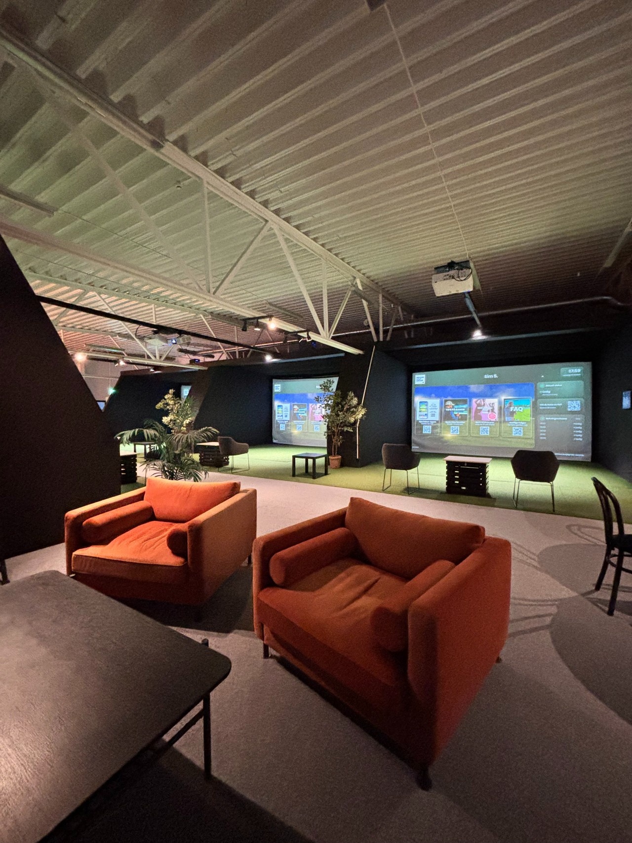 Fåtöljer framför simulatorerna på Vallentuna Indoor Golf