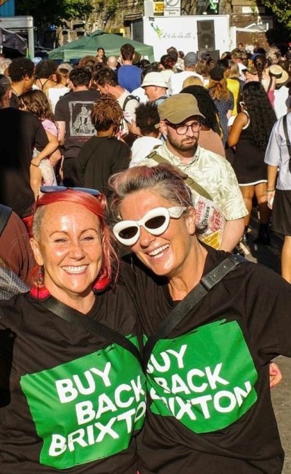 Selfie of our very own Morgane and Fran, wearing their Buy Back Brixton T-shirt. They are amongst the crowd gathered for the Buy Back Brixton Rally that took place on the 19th of July 2026 in Brixton.