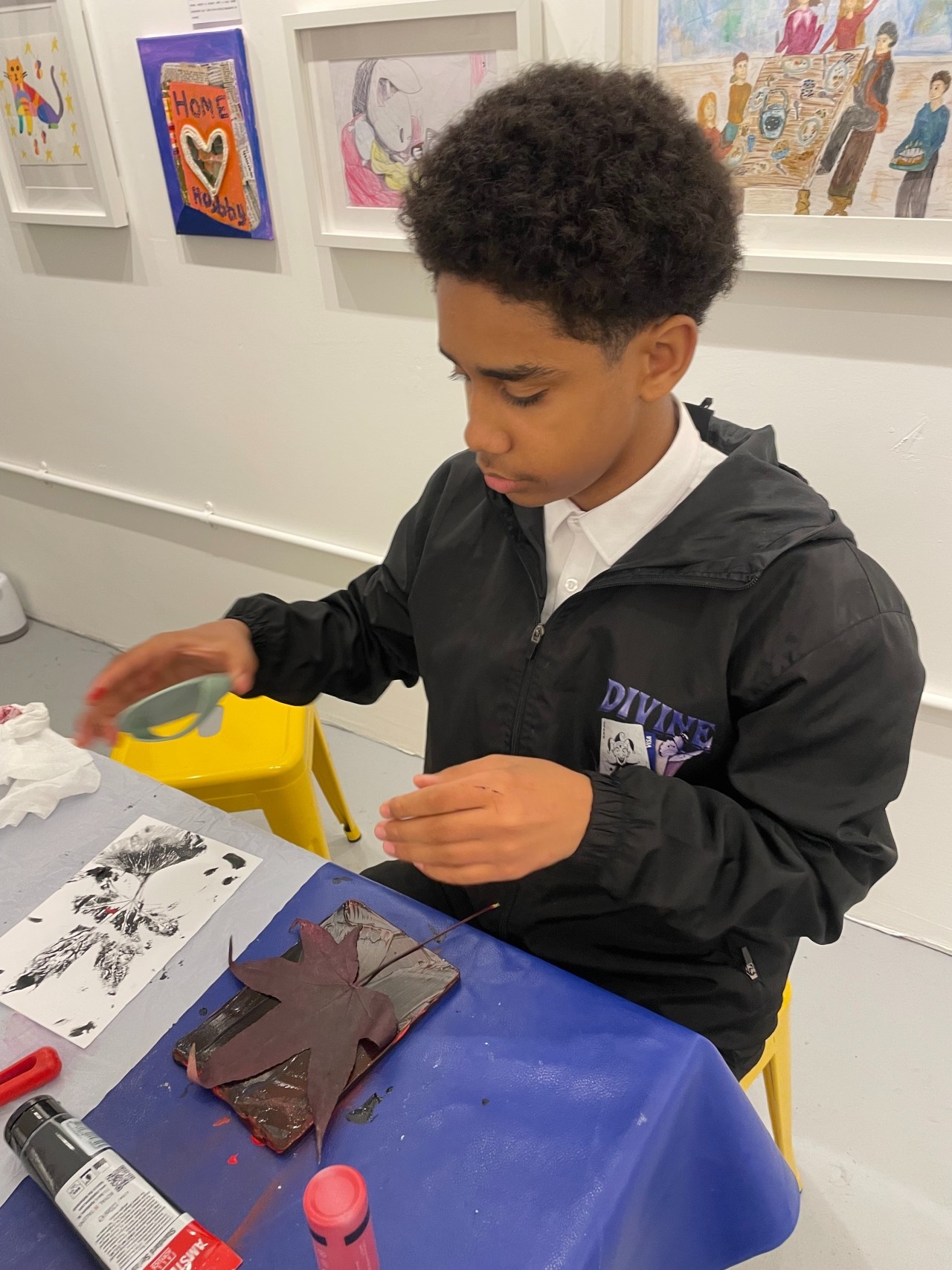 Photograph of a teenage boy doing leaf printing in one of our art classes.