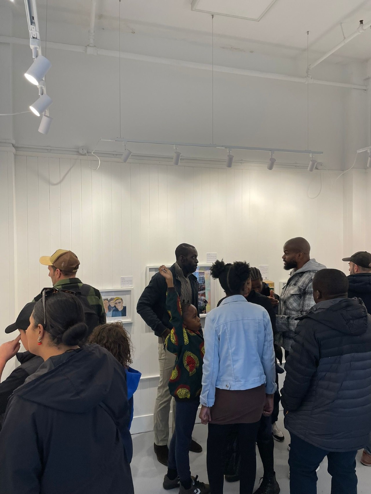 Group of people, adults and children inside the Space to Dream Gallery looking at the new selection of art on display in our second group show: HOME.