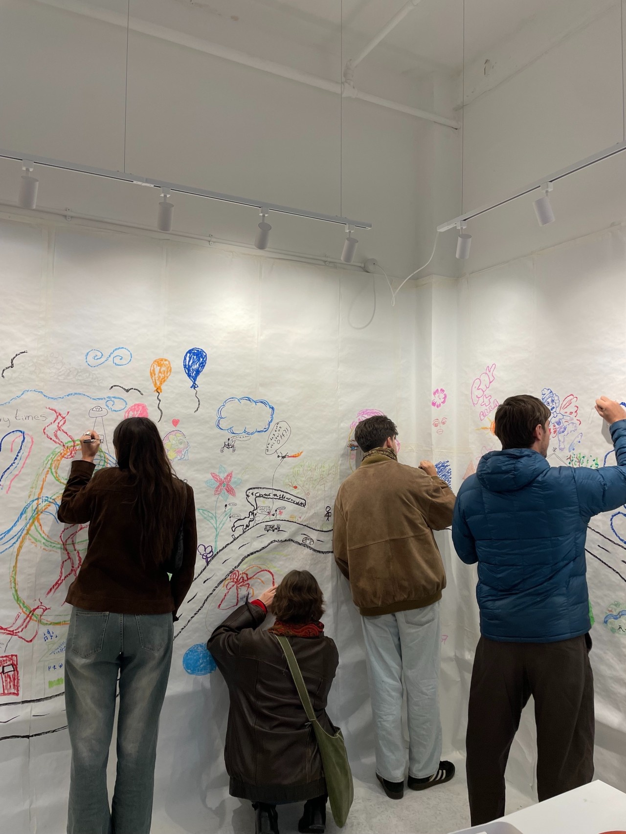 Four teenagers drawing on different parts of our collaborative mural.