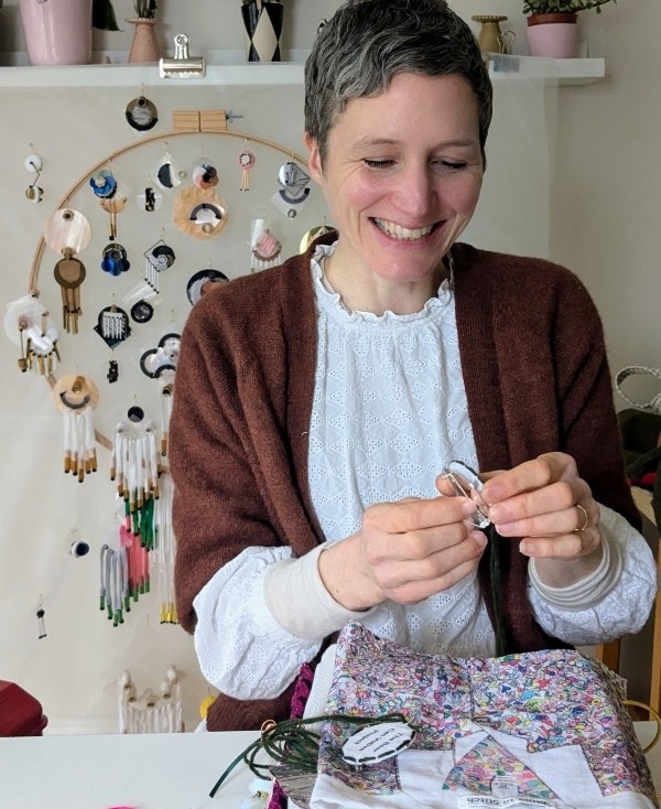 Portrait of Rachelle Francis, making buttons in her home or studio. Provided by Rachelle Francis