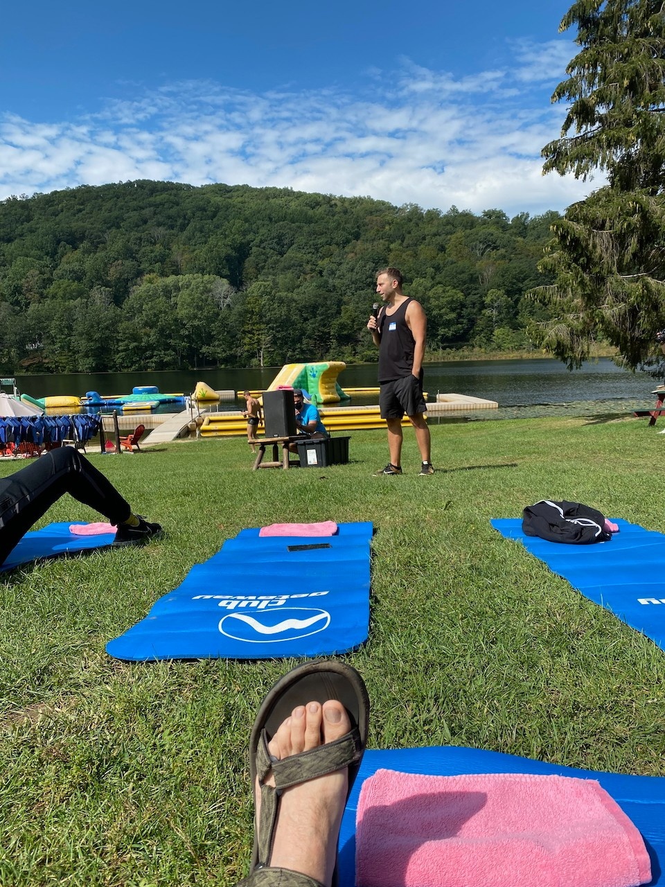 Yoga mats on green grass and Jacob with a microphone at Club Getaway in Connecticut