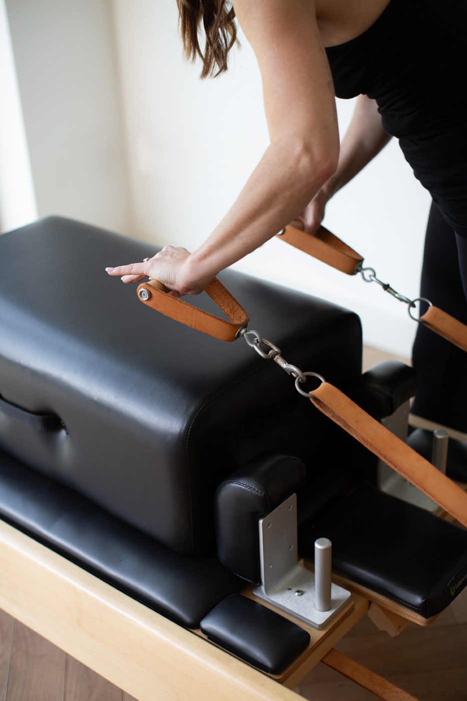 Hands on the straps of the Pilates Chair