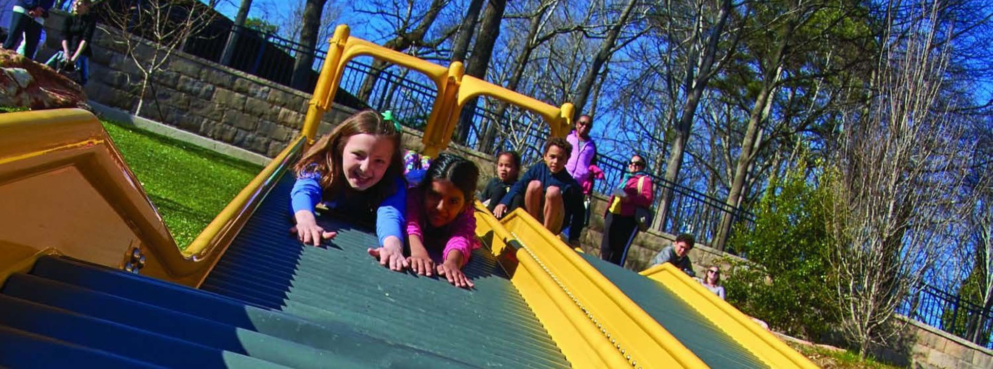 Kids sliding down a slide at Chastain Park