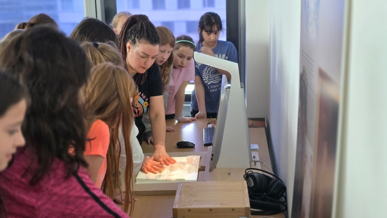 Bild: VRVis-Forscherin Cornelia Travnicek zeigt den Volksschülerinnen taktile Reliefe und den dazugehörigen Multimedia-Guide für Kunstwerke.