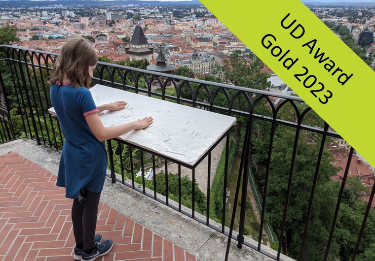 Bild: Mädchen berührt das taktile Panoramarelief des VRVis, welches als Dauerinstallation im Graz Museum Schlossberg zu erleben ist