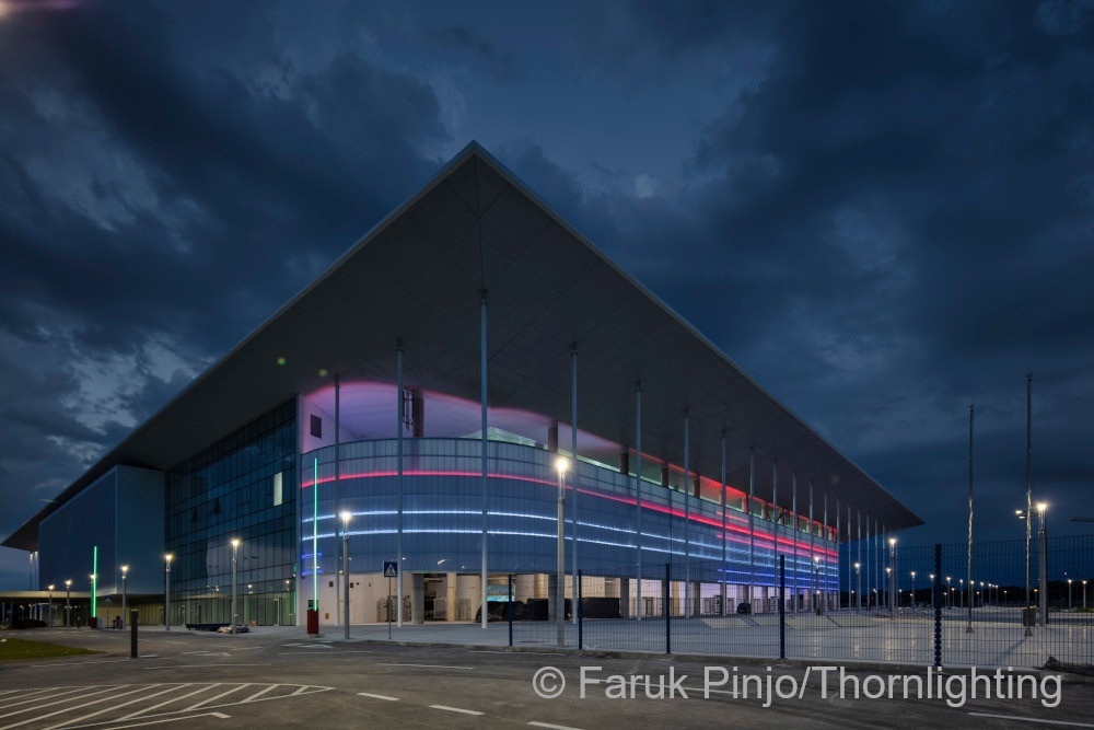 Bild: Glasfassade eines Fußballstadions mit roter und blauer Beleuchtung