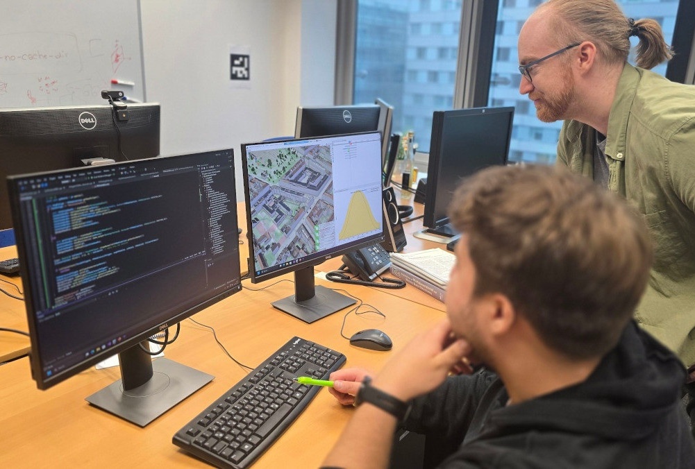 Bild: 2 VRVis-Forscher schauen auf einen Bildschirm, auf welchem das Sunny4Urban Planungstool zu sehen ist