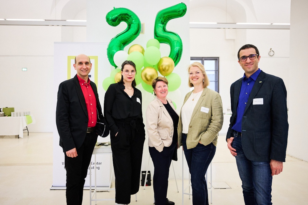 Bild: das VRVis-Team steht freundlich lächelnd vor vielen grün-weißen Luftballons sowie den Luftballon-Ziffern 25 anlässlich des Geburtstagsfestes des VRVis